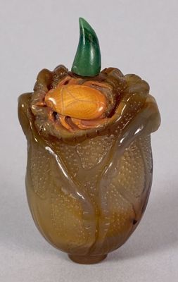 a glass vase with a green leaf on top of it