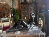 a statue of a woman sitting on a table in a living room