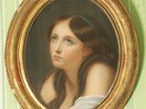 un tableau représentant une femme aux cheveux longs, dans un cadre doré