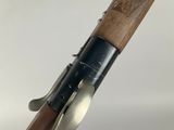 a close up of a shotgun with a wooden handle on a white background