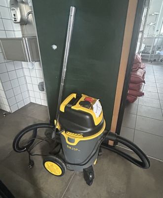 a vacuum that is sitting on the floor in the bathroom