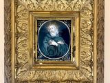 painting of a man with a beard in a gold frame on a wall