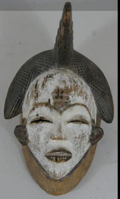 un masque blanc surmonté d'un oiseau