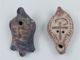 two pieces of pottery with a cross and a face on them