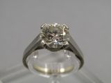 a close up of a diamond ring on a clear surface