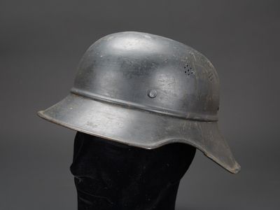 un vieux casque posé sur la tête d'un mannequin noir