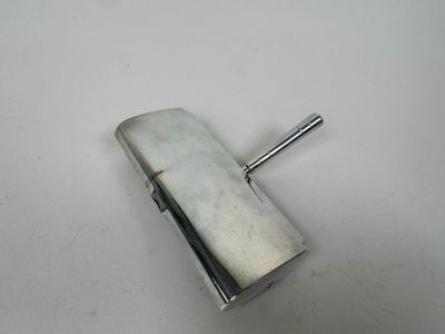 un vieux étui à cigarettes en argent posé sur une table blanche