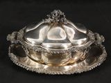 un plat en argent avec un couvercle en argent sur fond noir