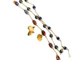 un gros plan sur un long collier orné de perles et de breloques