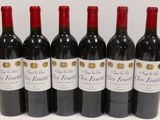 six bottles of red wine are lined up on a table