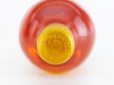 a close up of a bottle of honey on a white surface