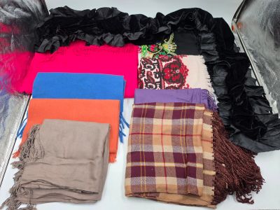 de nombreuses écharpes et foulards disposés sur une table
