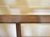 a wooden bench sitting in front of a white wall