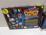 a box of magic show on the table next to a box of cards
