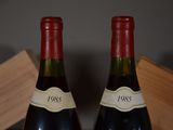 two bottles of wine sitting next to each other on a table
