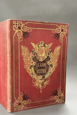 an old red book with gold trim and a golden crest on the cover