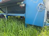 a blue trailer that is sitting in the grass