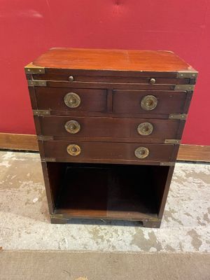 une vieille commode surmontée de ferrures en laiton