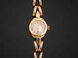 a gold wrist watch with a white dial on a black background