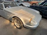 a silver car parked in a parking lot with other cars in the background