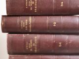 five old books stacked on top of each other on a table