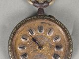une vieille montre de poche posée sur une table