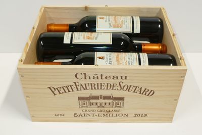 bouteilles de vin dans un coffret en bois sur une surface blanche