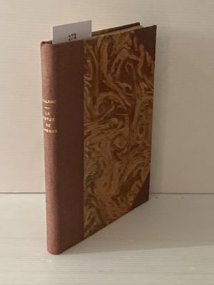 un vieux livre posé sur une table en bois à côté d'un mur blanc