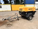 une petite machine attelée à une remorque dans un parking