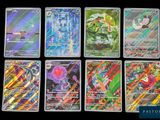 Les cartes Pokémon sont alignées sur une surface noire.