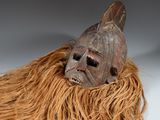 un masque marron avec de longs cheveux sur un fond blanc