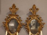 deux miroirs dorés fixés au mur, dans lesquels sont disposées des bougies