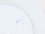 a white plate with blue writing on it on a table