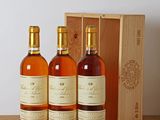 three bottles of wine in front of a wooden box on a table