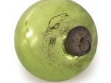 a green apple with a hole in it on a white surface
