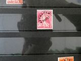 un homme debout devant un mur orné de timbres
