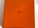 an orange box with a logo on it sitting on a white surface