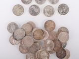 Plusieurs types de pièces de monnaie sont éparpillées sur une surface blanche
