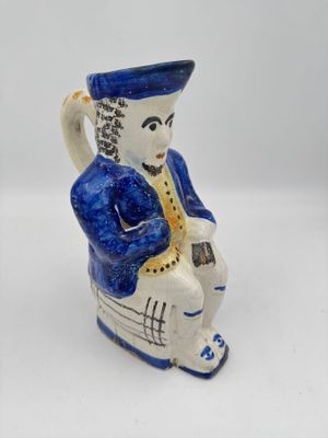 figurine en céramique bleue et blanche représentant un homme jouant d'un instrument de musique