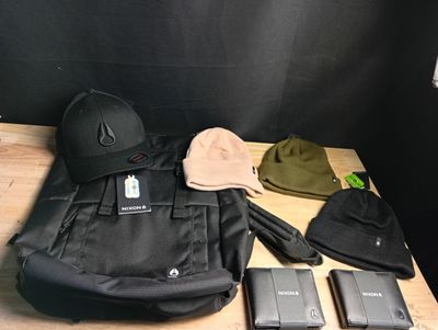 a hat, cell phone, wallet, and other items laid out on a table