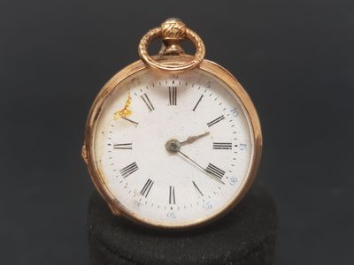 a gold pocket watch with roman numerals on the face