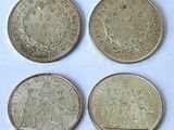 four different types of coins are shown on a white surface