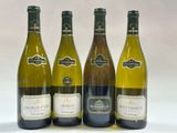 quatre bouteilles de vin sont alignées sur une surface blanche