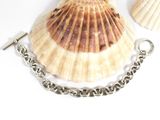 a shell with a chain around it on a white surface