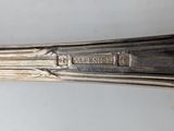 a silver spoon with a silver handle on a white table