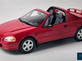 a red toy car that is sitting on a white surface
