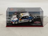a toy car in a display case on a white surface