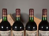 three bottles of wine sit in a wooden crate on a table