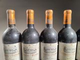 six bottles of wine are lined up on a table