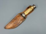 an old knife with a wooden handle sitting on top of a table